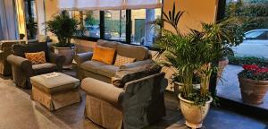 a living room with couches and potted plants at Hotel La Capannina in Genoa +29 photos
