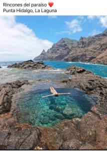 a person laying in a pool of water in the ocean at La Casita de Omar en el corazón de Anaga y La Laguna in Las Mercedes