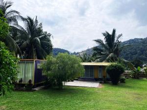 a house with palm trees in a yard at Purple Cube at Lumut Cube Homestay Kontena in Lumut