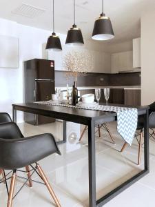 Stylish & Cozy Stay at Suasana Suites JB 11 في جوهور باهرو: غرفة طعام مع طاولة وكراسي سوداء