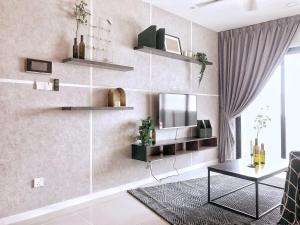 Stylish & Cozy Stay at Suasana Suites JB 11 في جوهور باهرو: غرفة معيشة فيها تلفزيون على جدار