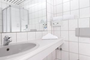 a white bathroom with a sink and a mirror at Good Morning + Bad Oldesloe in Bad Oldesloe +18 photos