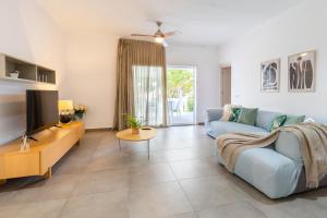 ein Wohnzimmer mit einem blauen Sofa und einem Fernseher in der Unterkunft Luxury Villa Premium Salinas in Santa Pola