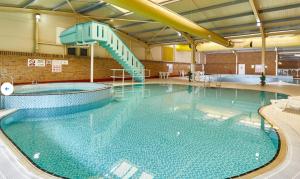 a large swimming pool with a slide in it at Chalet K94 - Sunset View in Camber