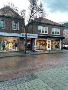 una tienda en una calle con un árbol enfrente en Have a nice stay! - Ruim appartement de Molen, en Noordwijk 7 fotos más