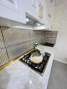 a kitchen with a stove with a tea pot on it at Sumqayit citi in Sumqayıt