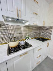 a kitchen with white cabinets and a pot on the stove at Sumqayit citi in Sumqayıt