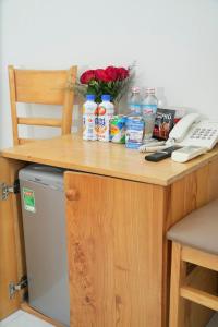 a wooden desk with a counter top with a refrigerator at Biển Nhớ Hotel & Coffee in Phan Thiet