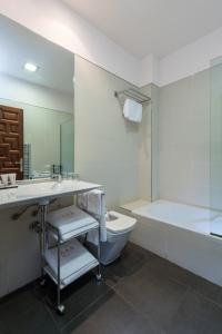 a bathroom with a tub and a sink and a toilet at Gar Anat Hotel Boutique in Granada