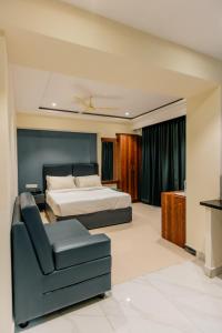 a bedroom with a bed and a couch and a chair at No 7 Vista in Bengaluru