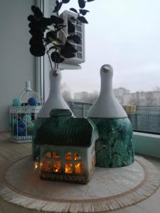 two vases sitting on top of a table with a house at Few Steps to the Bay in Jūrmala