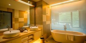 bagno con 2 lavandini, vasca e specchio di 张家口云顶大酒店 a Chongli