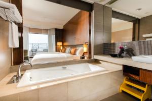 bagno con grande specchio e vasca di Silks Place Yilan a Città di Yilan
