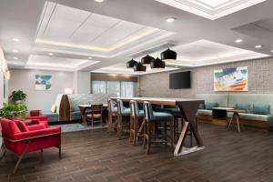a lobby with a bar and chairs and a waiting room at Hampton Inn Chicopee - Springfield in Chicopee
