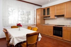 a kitchen with a table with a vase of flowers on it at Apartment Lidija in Podgora