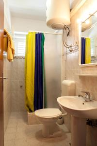a bathroom with a shower curtain and a sink at Apartment Lidija in Podgora