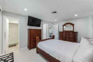 a bedroom with a bed and a dresser and a television at Riverside Retreat: Deck Bar, FirePit, Boat Parking in Fort Myers
