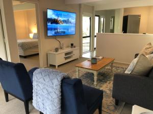 a living room with two chairs and a tv at Relax in Red Beach! in Red Beach