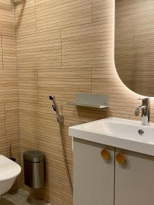 a bathroom with a sink and a toilet and a mirror at EnjoyNature Resort in Lahti +86 photos