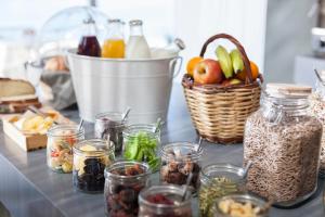 a table with jars of food and a basket of fruit at Coco-Mat Eco Residences Serifos in Vayiá
