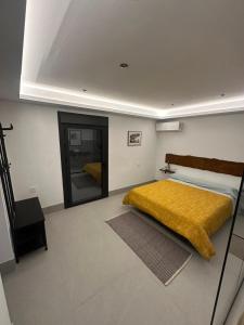 a bedroom with a bed with a yellow blanket on it at Bellavista in Setenil