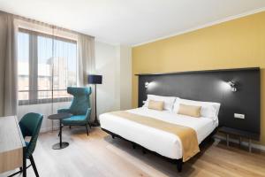 a bedroom with a bed and a desk and a chair at Hotel Alimara in Barcelona