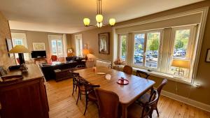 Una sala de estar con una gran mesa y sillas de madera. en Villa Les Moullières 14pers, en Le Mont-Dore