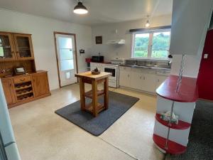 a kitchen with a table in the middle of it at River Farm Retreat in Mangaweka