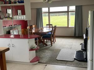 a kitchen and dining room with a table and a television at River Farm Retreat in Mangaweka +27 photos