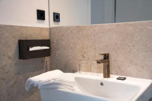 a bathroom with a white sink and a mirror at Hanse House Wismar in Wismar +51 photos