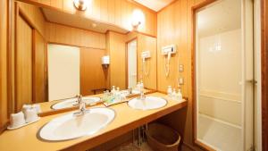 a bathroom with two sinks and a large mirror at Nishiizu Koyoi in Numazu