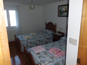 a bedroom with two beds and a window at Apartamento Casa Jeronimo in Taramundi +6 photos