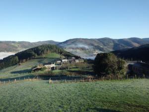 a farm in a field with mountains in the background at Apartamento Casa Jeronimo in Taramundi