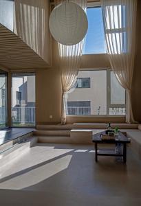 a living room with a table and large windows at 无终隅民宿 in Jizhou
