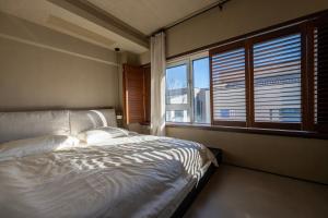 a bedroom with a bed and a large window at 无终隅民宿 in Jizhou