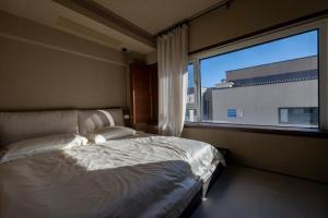 a bedroom with a bed and a large window at 无终隅民宿 in Jizhou