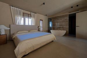a bedroom with a large bed and a bath tub at 无终隅民宿 in Jizhou
