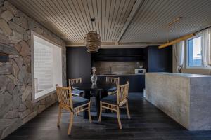 a dining room with a table and chairs and a stone wall at 无终隅民宿 in Jizhou