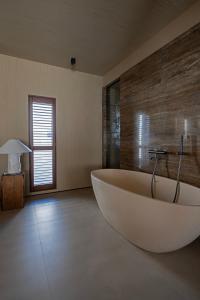 a large white tub in a bathroom with a window at 无终隅民宿 in Jizhou