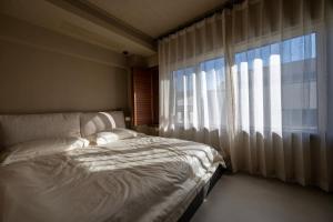 a bedroom with a bed and a large window at 无终隅民宿 in Jizhou