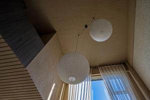 two white lights hanging from the ceiling of a room at 无终隅民宿 in Jizhou