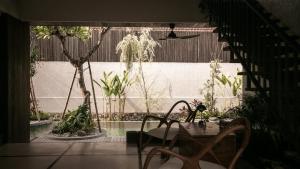 a patio with a table and chairs and plants at New Little Ripper Boutique Hotel in Tanah Lot