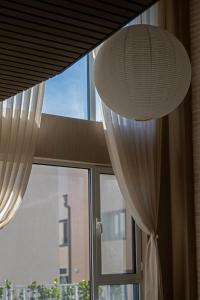 a large window with white curtains and a lamp at 无终隅民宿 in Jizhou