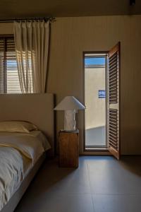a bedroom with a bed with a lamp and a window at 无终隅民宿 in Jizhou