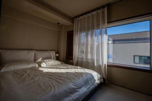 a bedroom with a bed and a large window at 无终隅民宿 in Jizhou