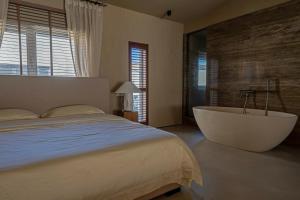 a bedroom with a large bed and a bath tub at 无终隅民宿 in Jizhou
