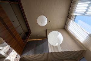 two white lights hanging from the ceiling of a room at 无终隅民宿 in Jizhou