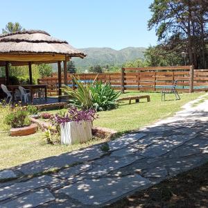 a patio with a gazebo and a table and bench at Cabañas Del Alto in Villa Giardino +17 photos