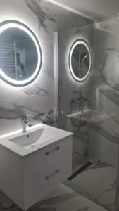 a white bathroom with a sink and a mirror at Morski Brzeg in Świnoujście +28 photos