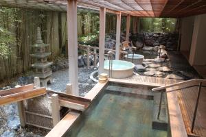 a bathroom with a bath tub in a garden at Hanabishi Hotel in Hakodate